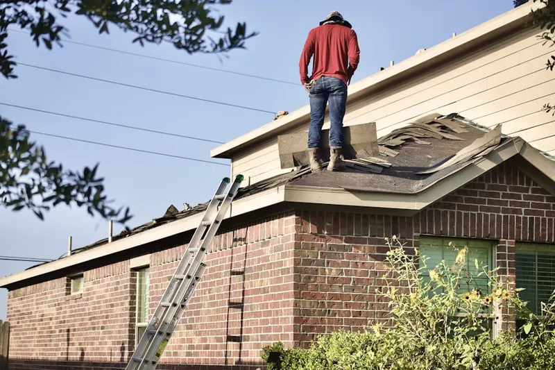 Professional roofer working on a residential roof in Wasilla